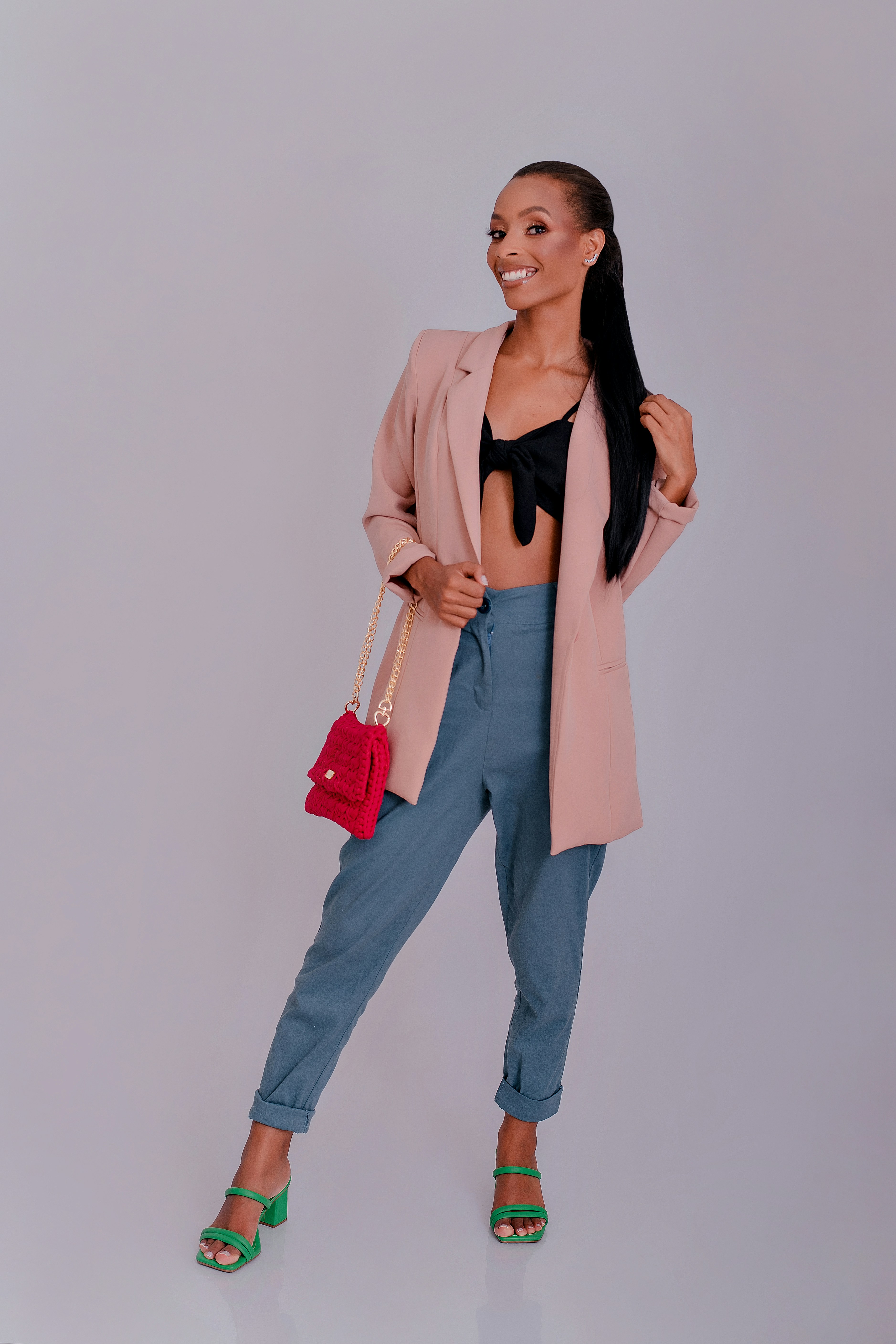 a woman in a pink blazer and blue pants