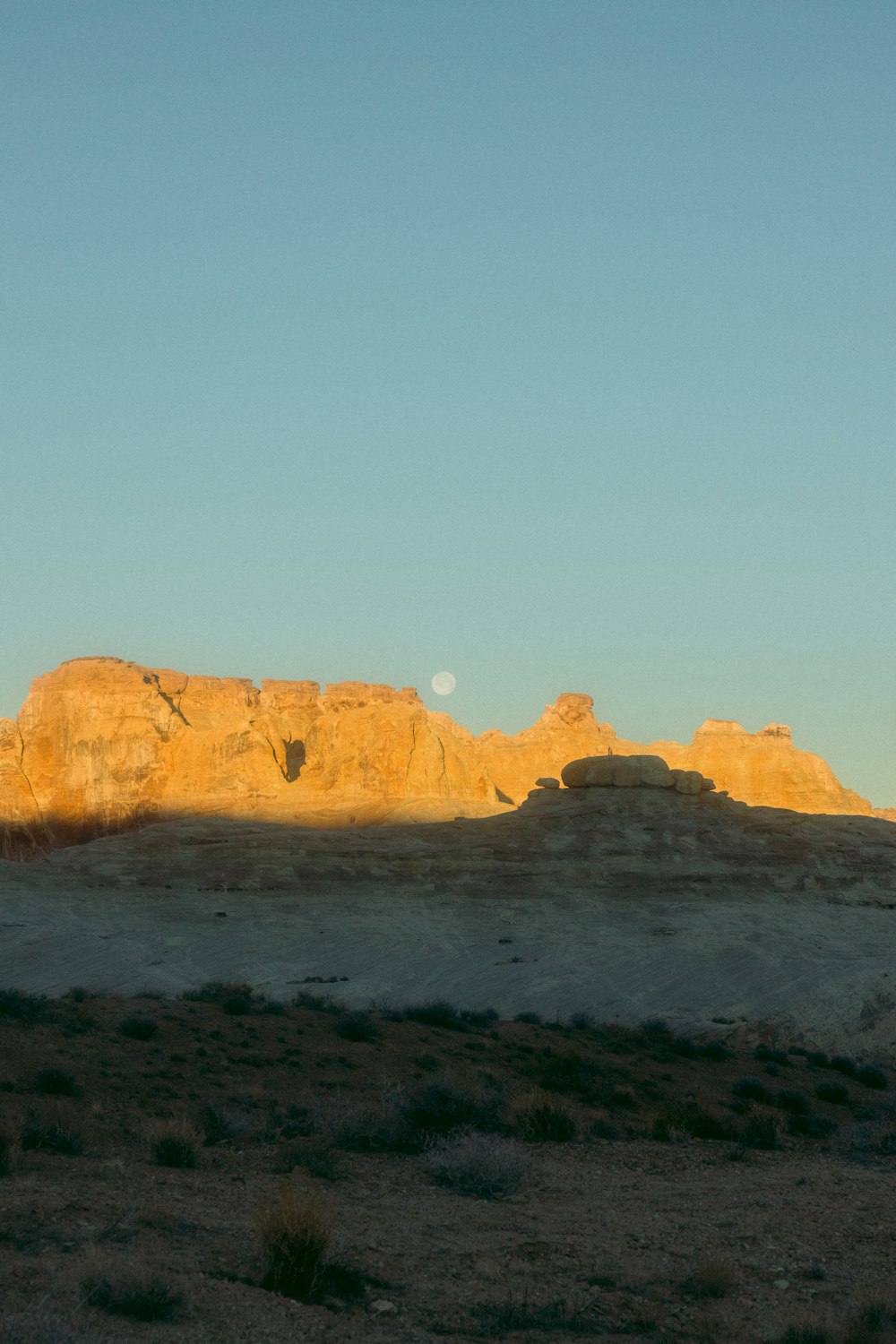 the sun is setting over the mountains in the desert