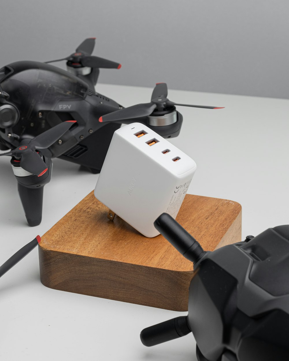 a couple of remotes sitting on top of a wooden block