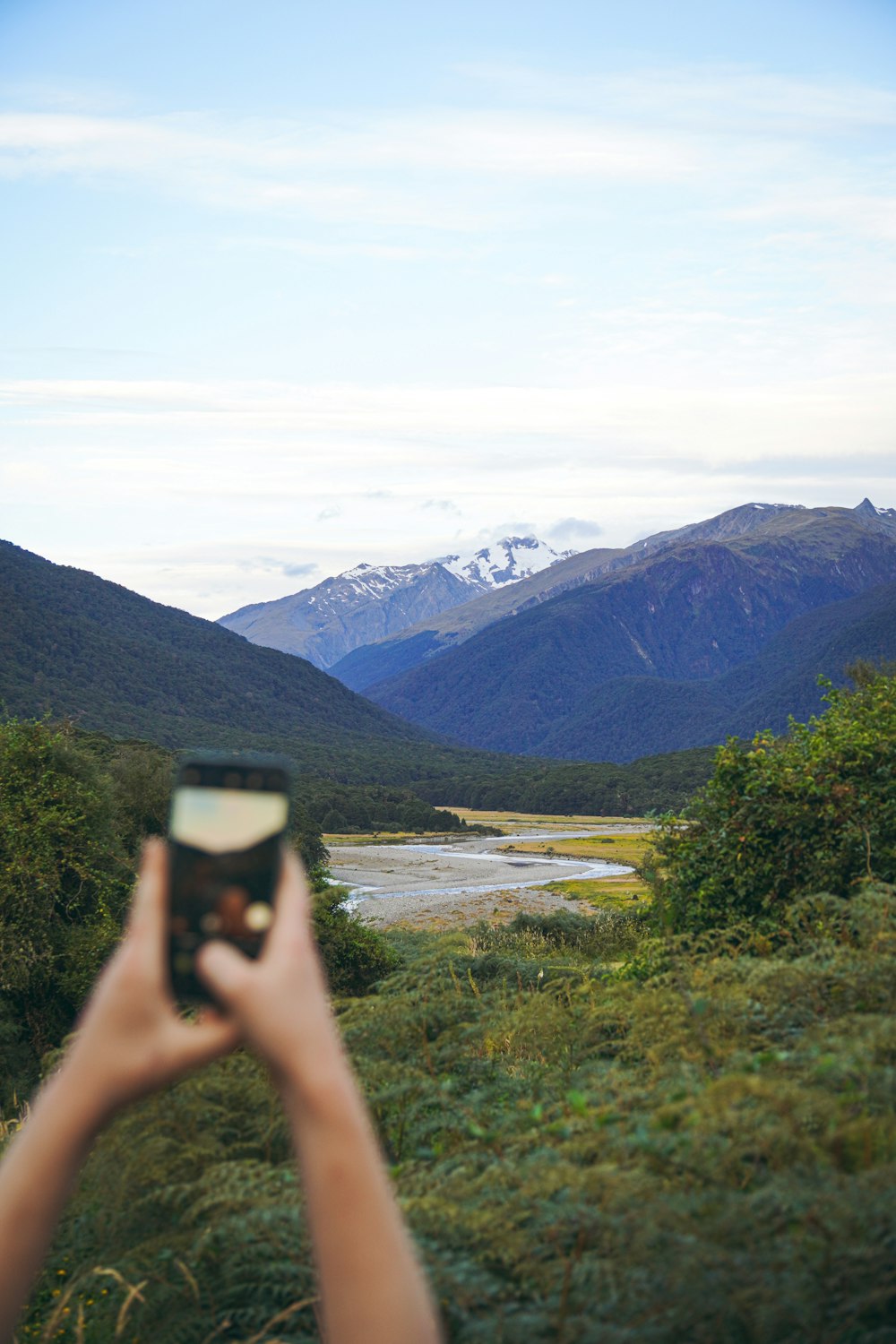 a person taking a picture of a mountain range