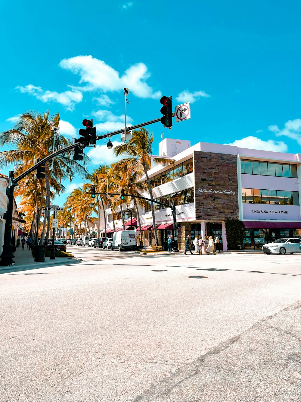 a city street with a traffic light and palm trees