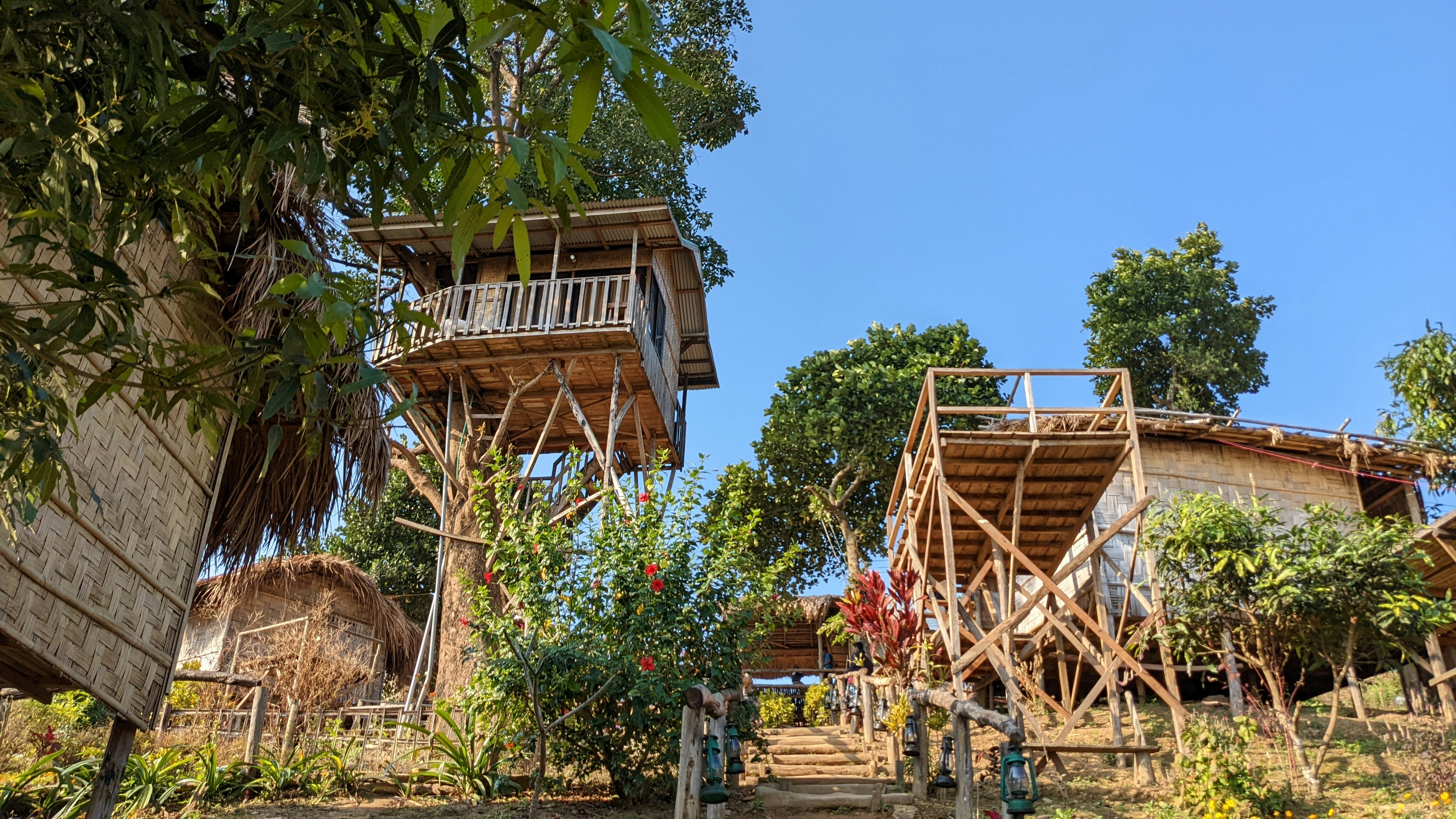 a couple of wooden buildings sitting on top of a lush green hillside