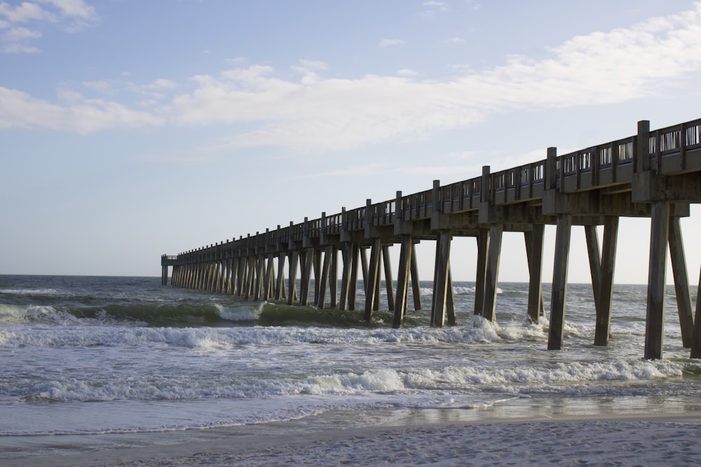 a long pier stretches out into the ocean