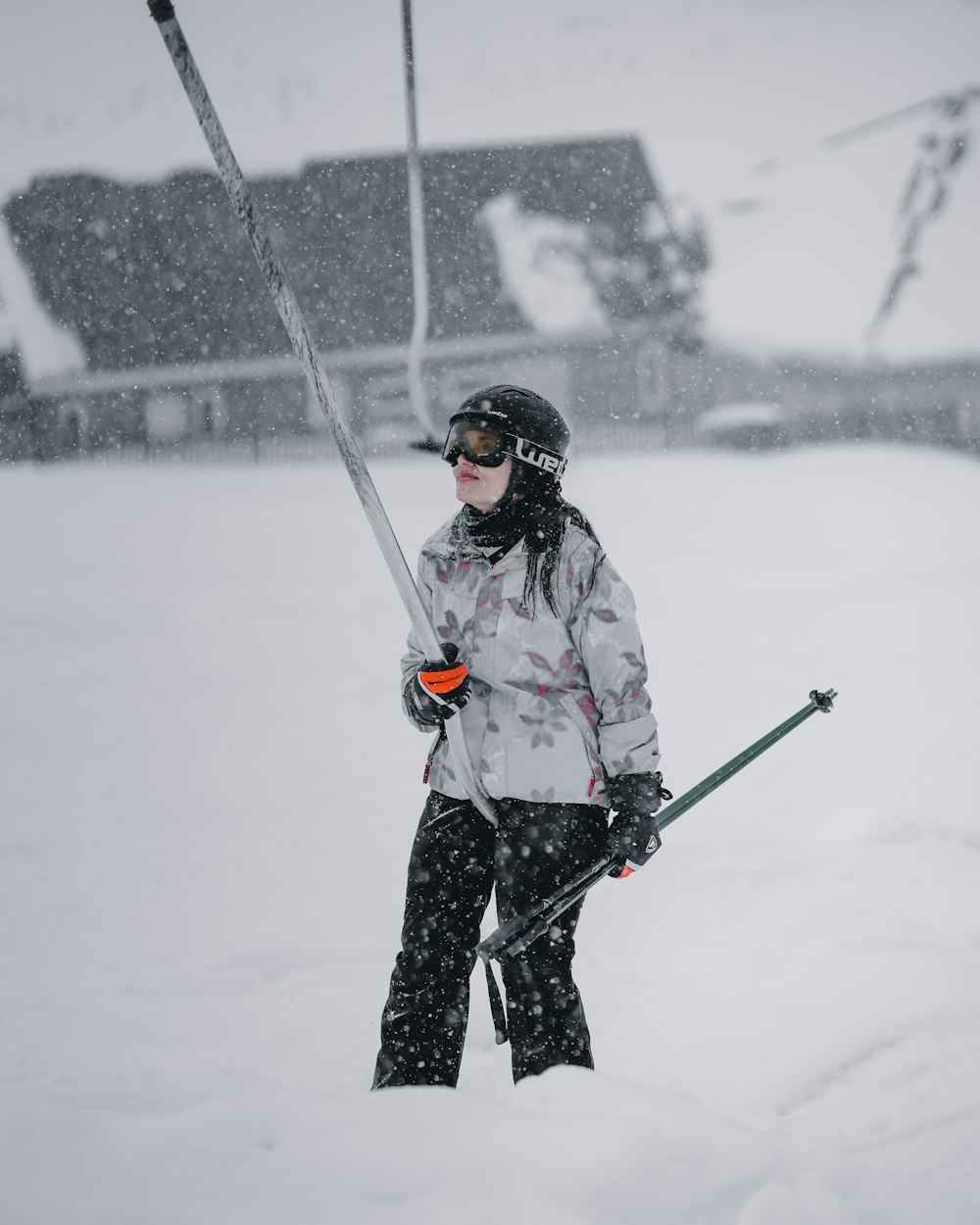 a woman holding skis and poles in the snow