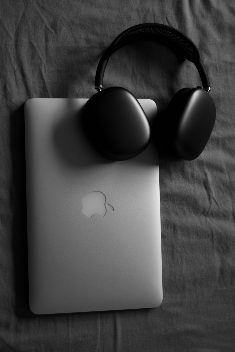 a black and white photo of headphones and a laptop