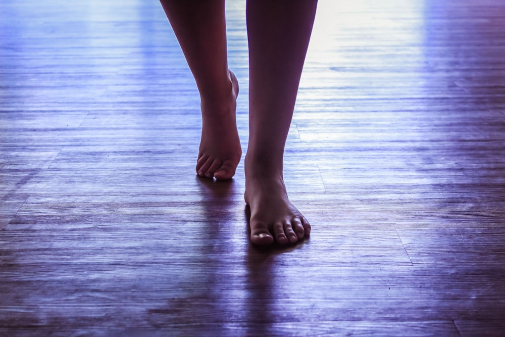 un primo piano dei piedi nudi di una persona su un pavimento di legno