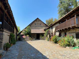 A cozy courtyard garden surrounded by rustic Antalya homes under a clear sky.