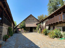 Sunlit courtyard of the medieval fort with blooming flowers and rustic benches.