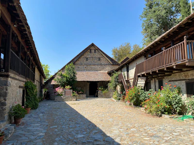 A cozy courtyard garden surrounded by rustic Antalya homes under a clear sky.