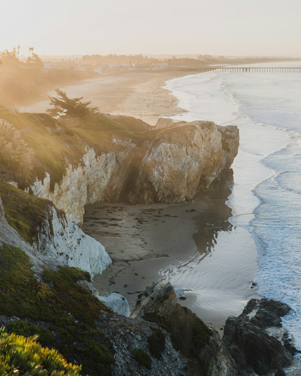 a view of a beach with a bridge in the background