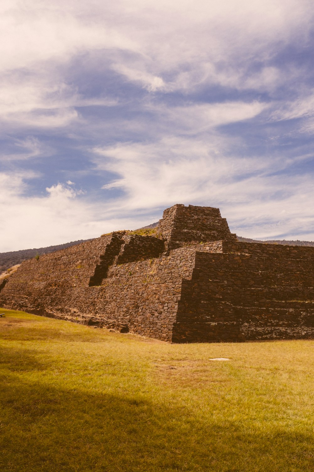 a large stone structure sitting on top of a lush green field