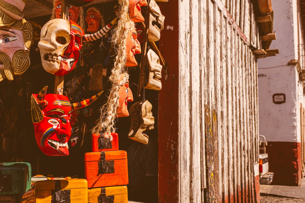 a group of masks hanging from the side of a building