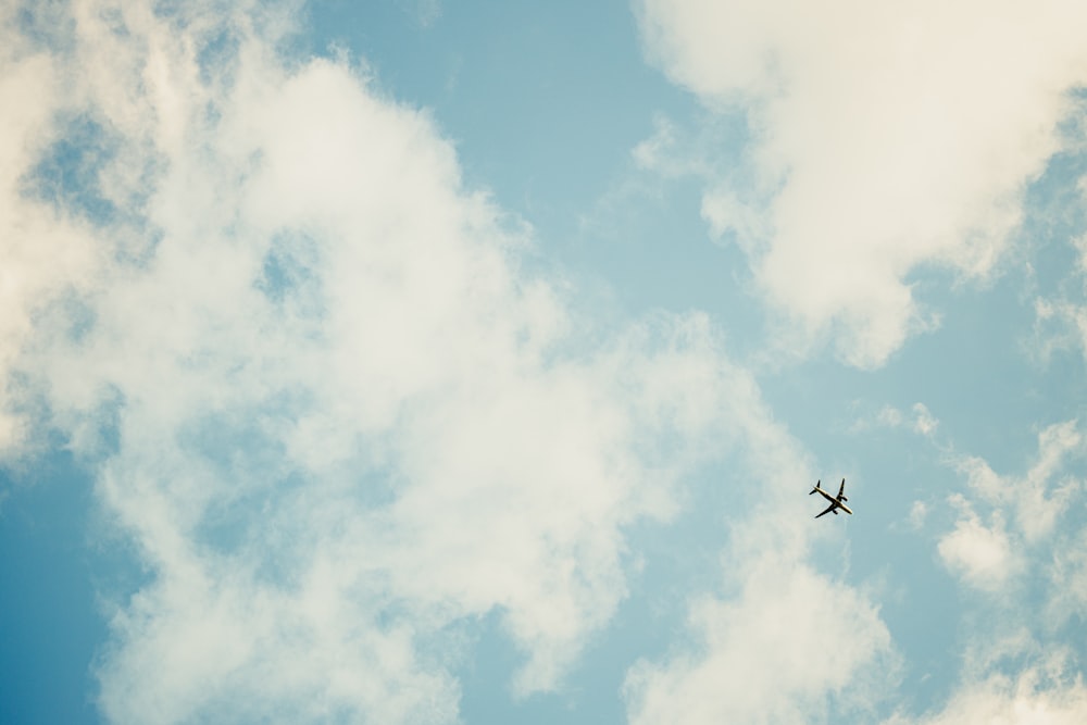 an airplane is flying through the cloudy sky