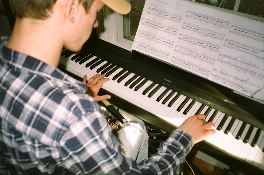 a man sitting at a piano playing a musical instrument