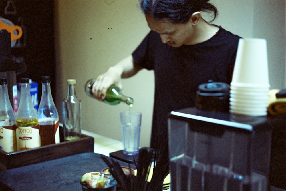 a woman pouring a drink into a glass