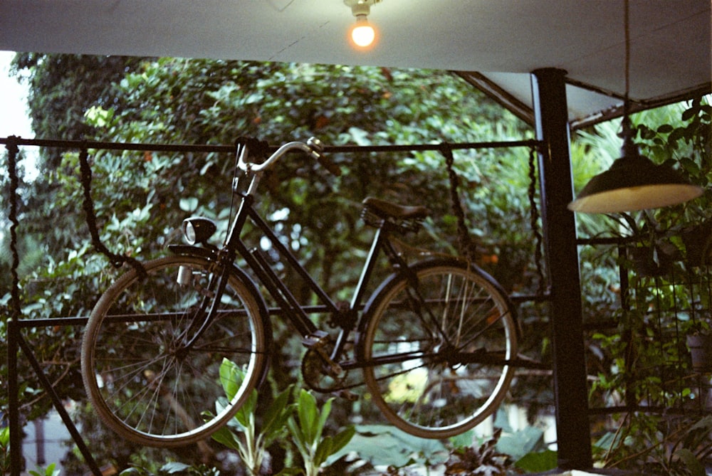 a bicycle is hanging from a metal fence