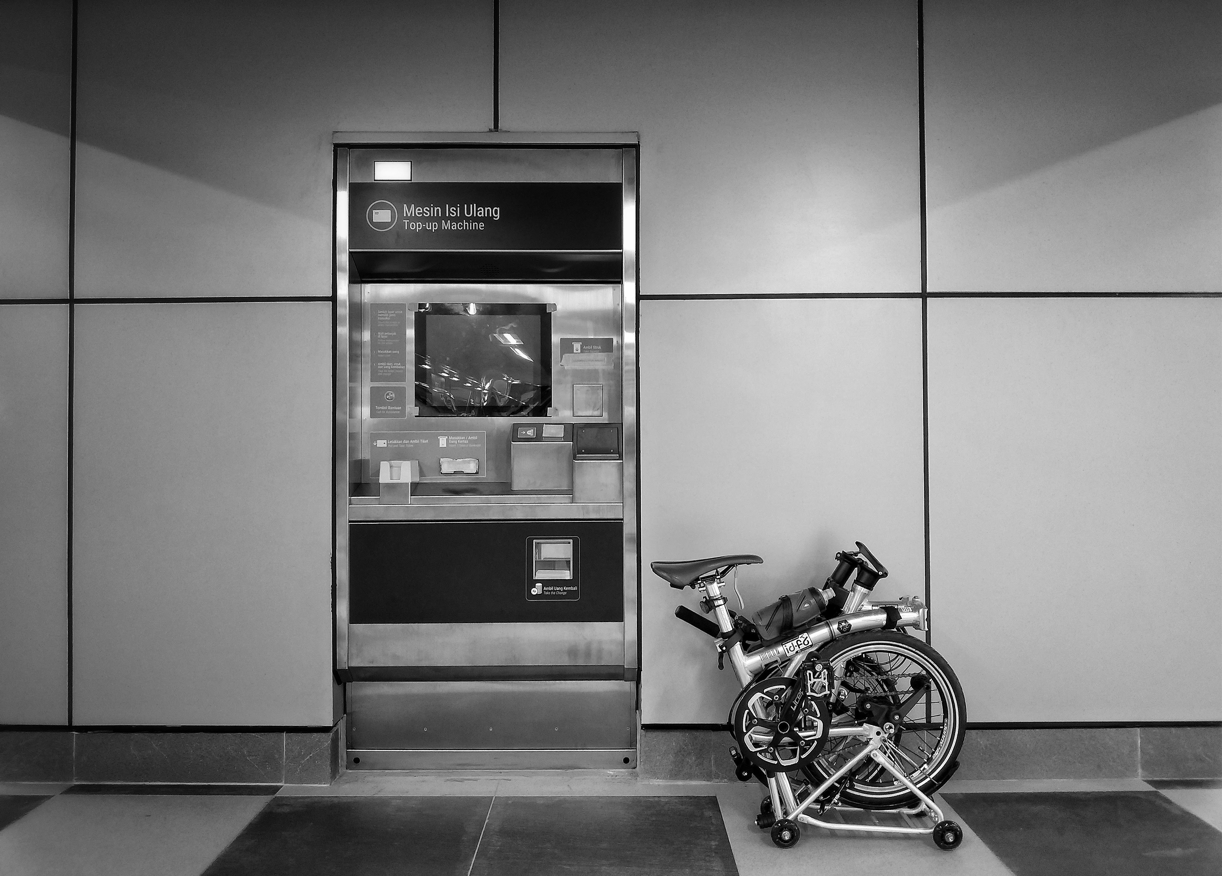 a bicycle parked next to a atm machine