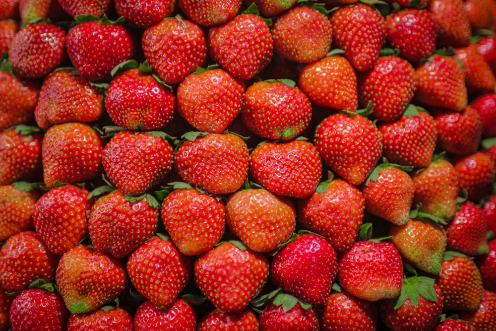 a pile of ripe strawberries sitting on top of each other
