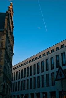 a very tall building with a plane flying in the sky