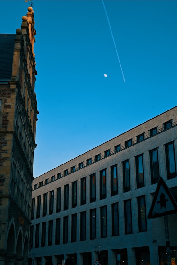 a very tall building with a plane flying in the sky