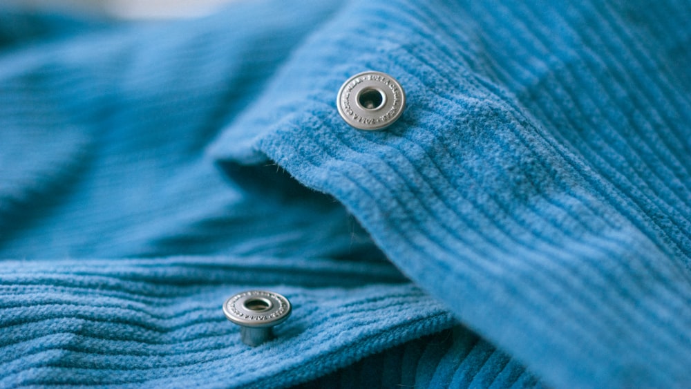 a close up of two buttons on a blue sweater