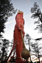 Hanumanji murti near Shimla set against lush green hills and clear blue sky