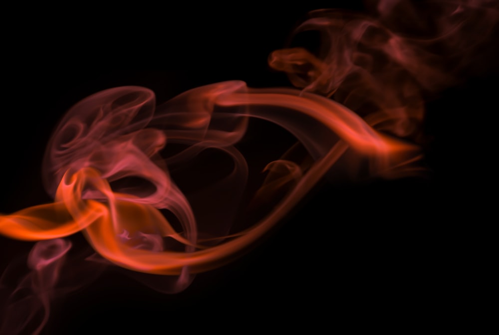 a red and yellow smoke is on a black background