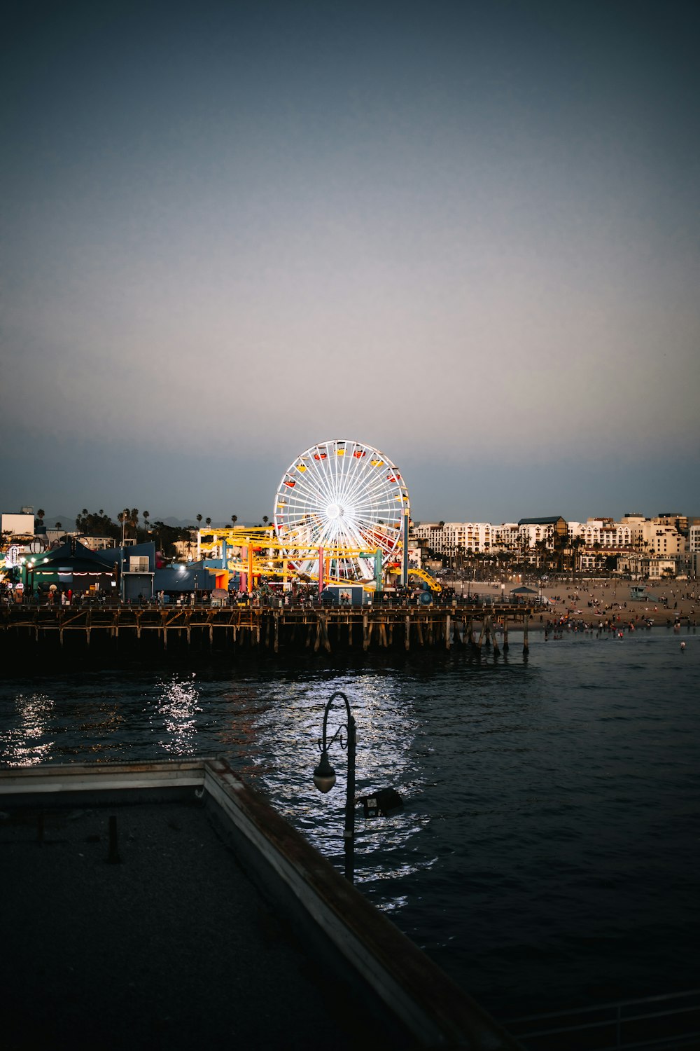 a ferris wheel sitting on top of a pier next to a body of water