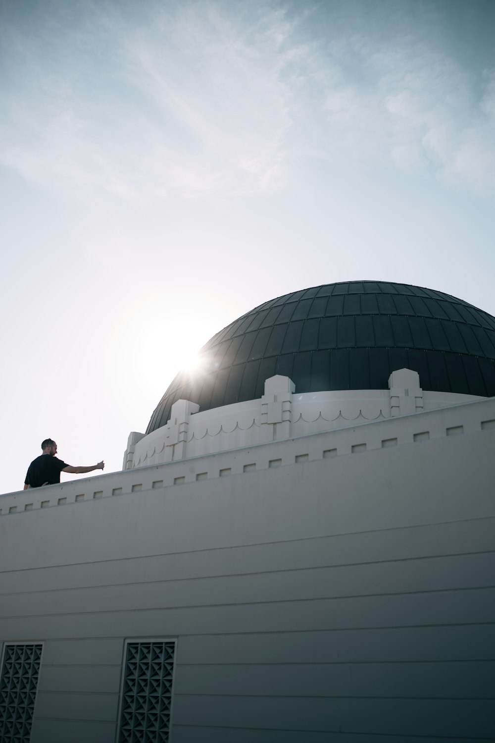 a man standing on top of a white building