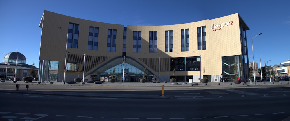 a large building with a curved roof and a street in front of it