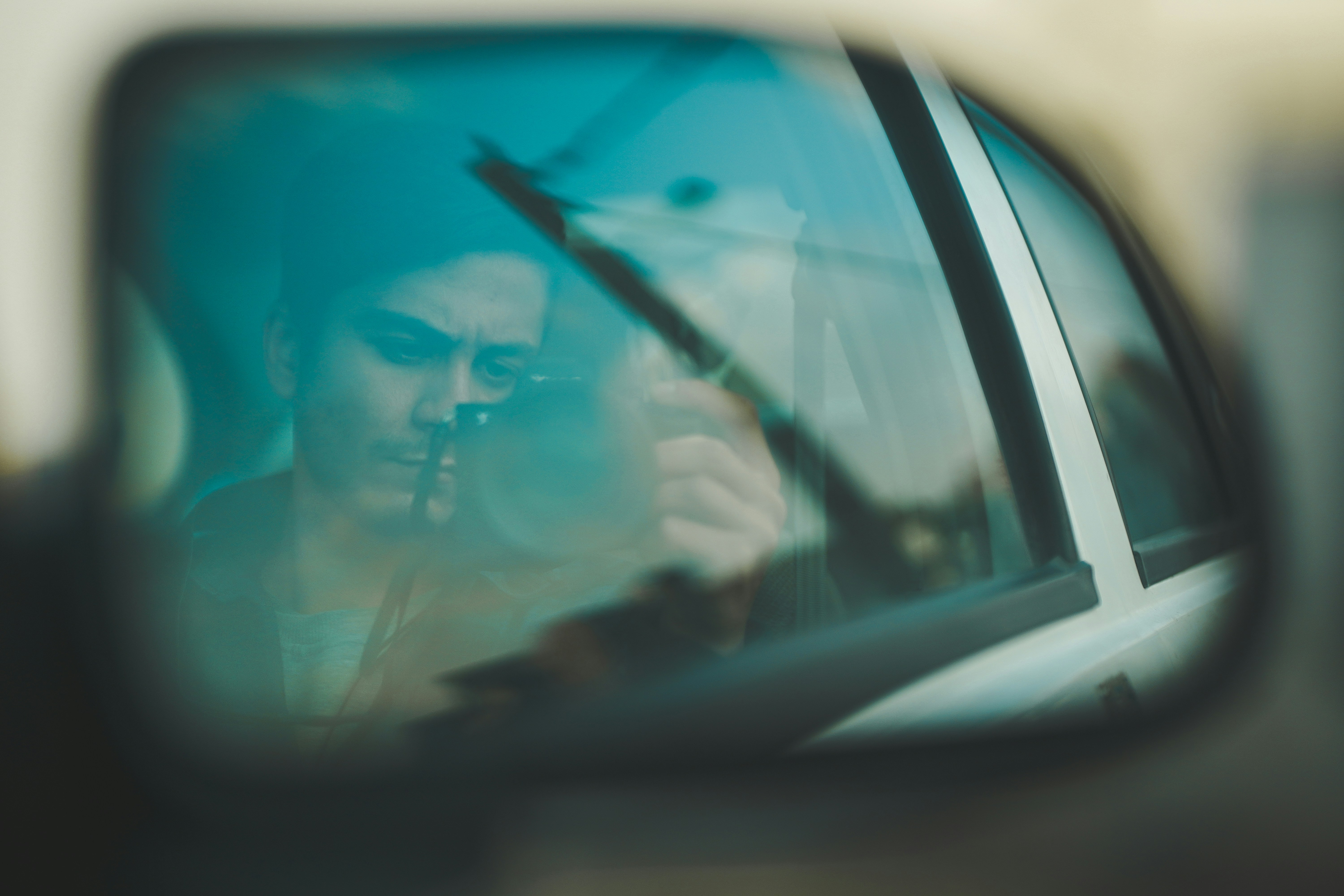 a woman taking a picture of herself in a car mirror