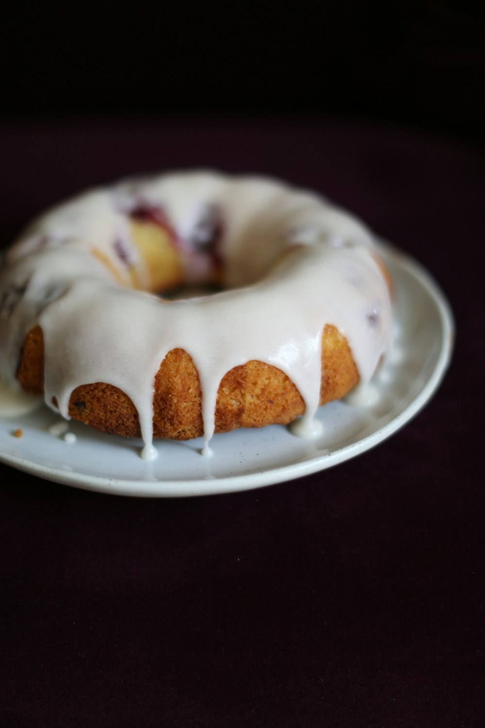 a white plate topped with a bundt cake covered in icing