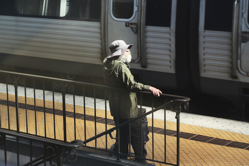 Un hombre parado en un riel junto a un tren