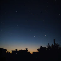 A dramatic cinematic cityscape silhouette at twilight, lights twinkling like stars.