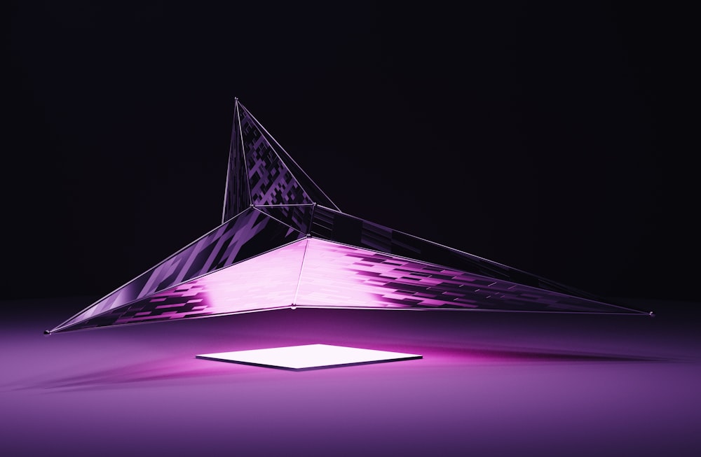 a purple light is shining on a triangular object