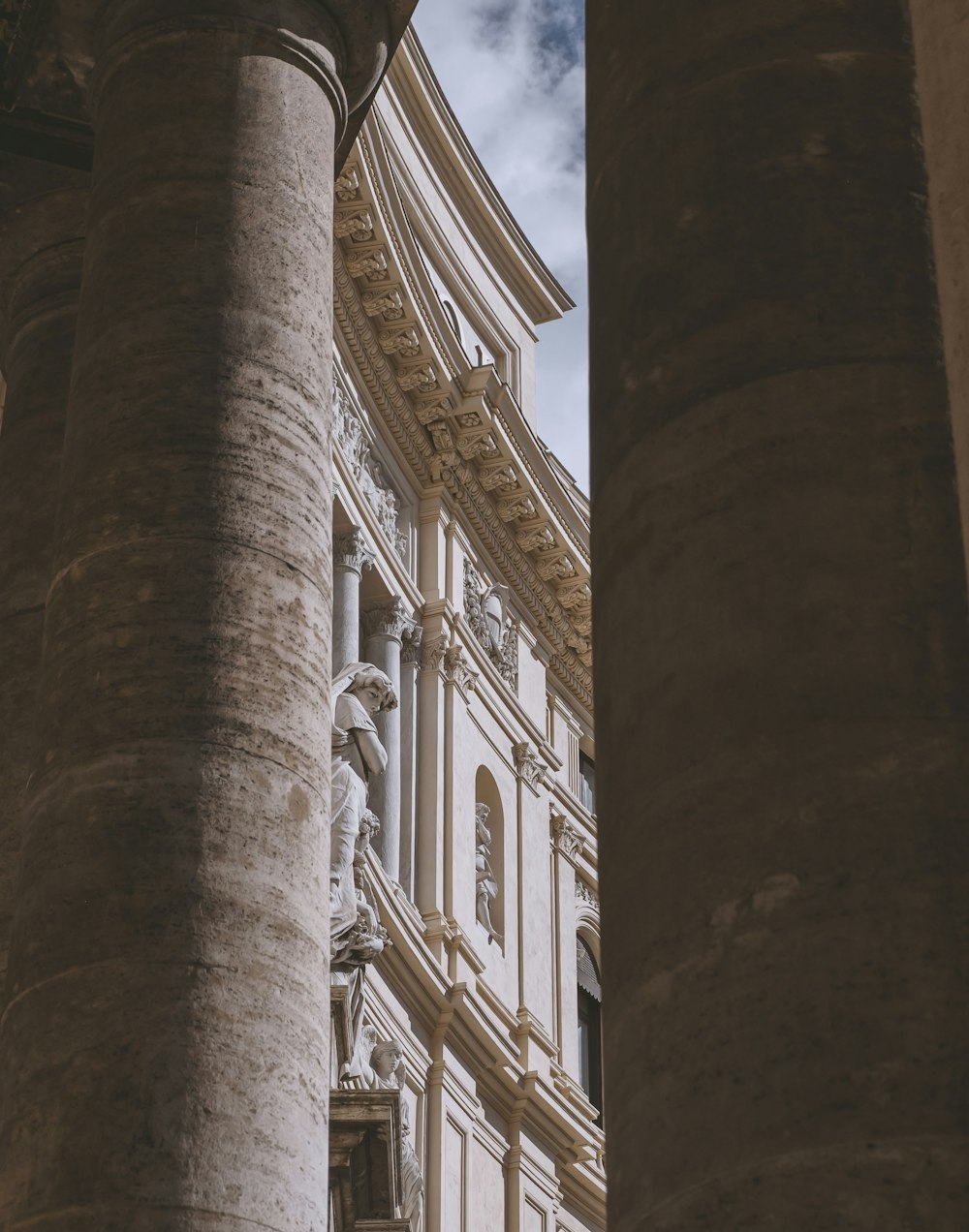 a building with columns and a clock on the side of it