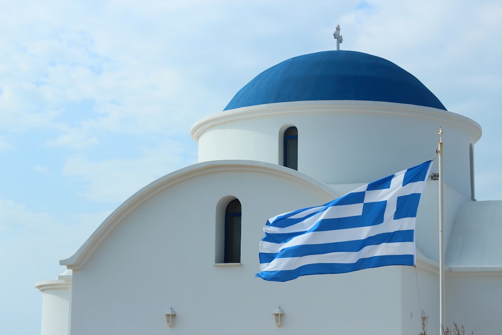 a greek flag flying in front of a church