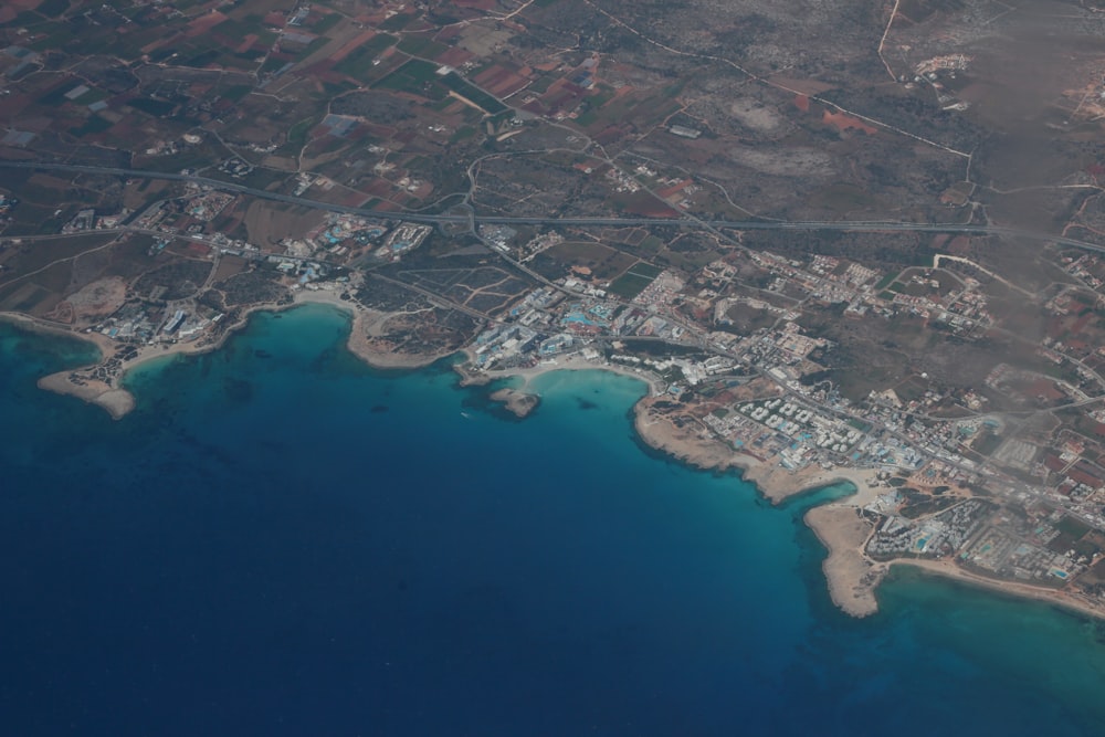 an aerial view of a city next to a body of water