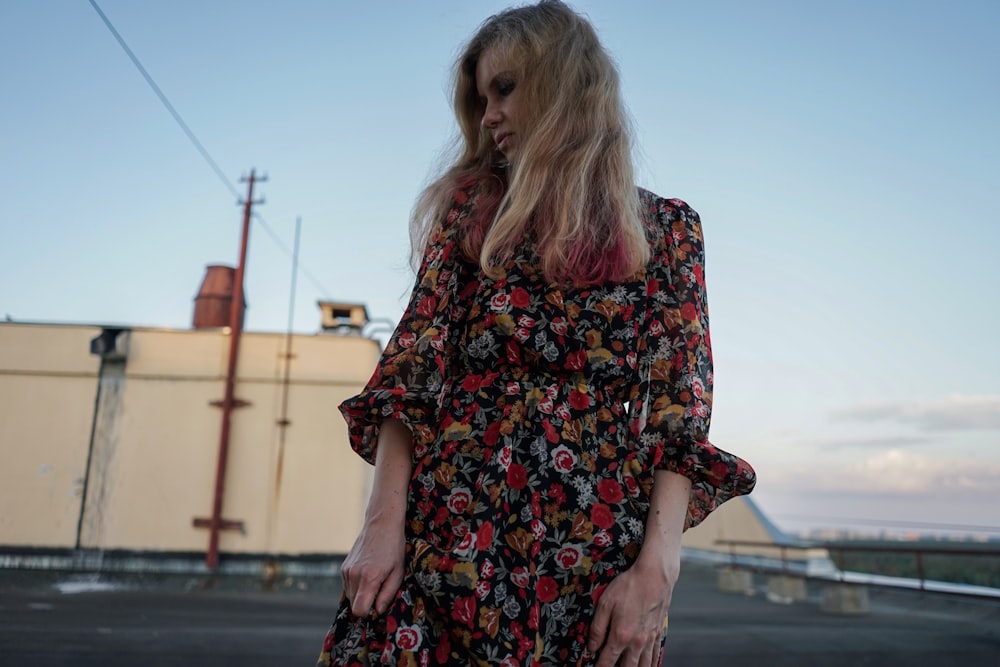 a woman standing in a parking lot with her hands in her pockets