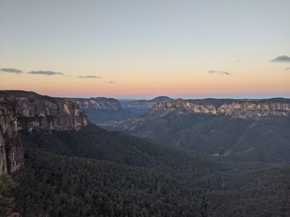 a scenic view of a mountain range at sunset