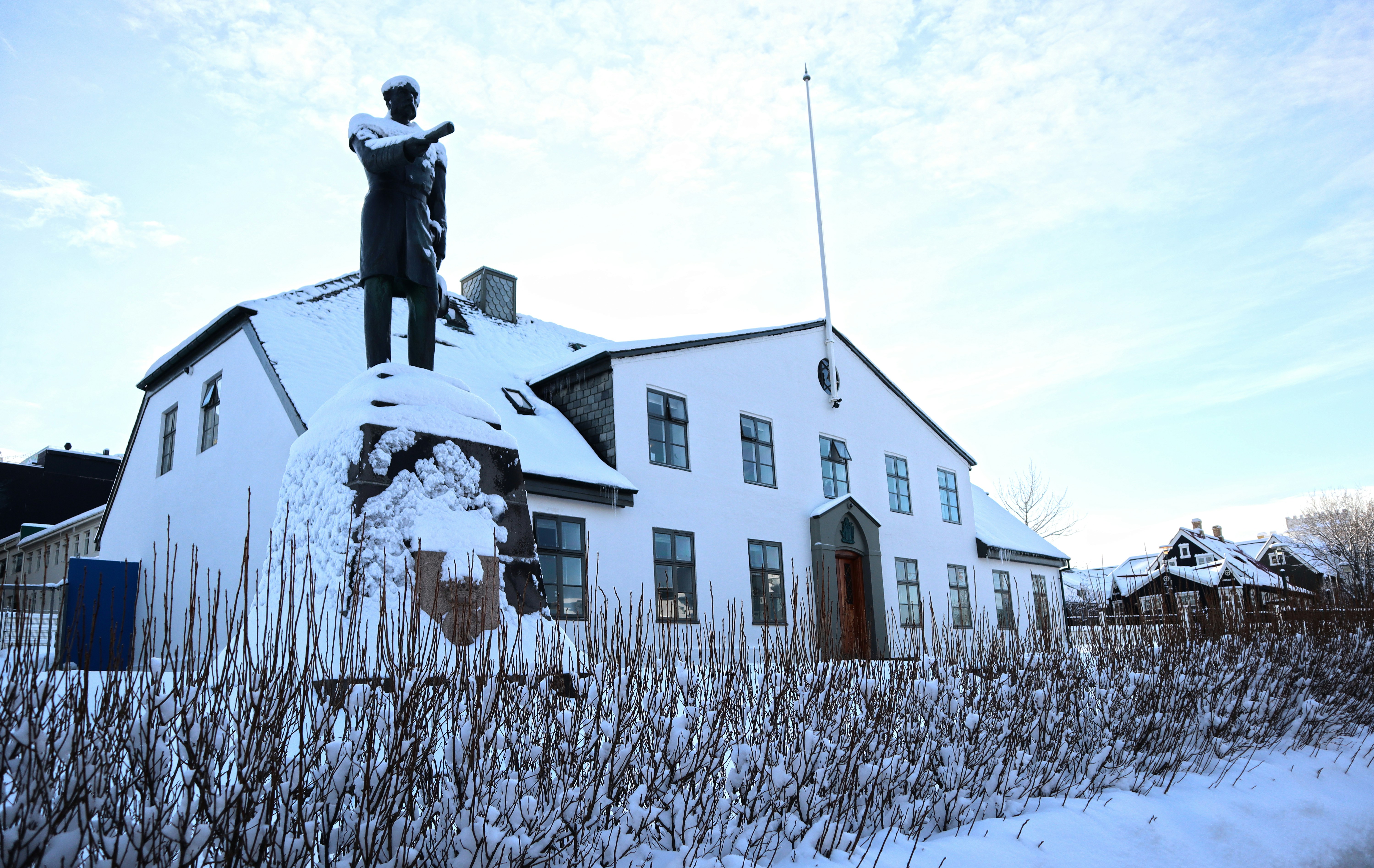 uma estátua de um homem em pé no topo de um edifício