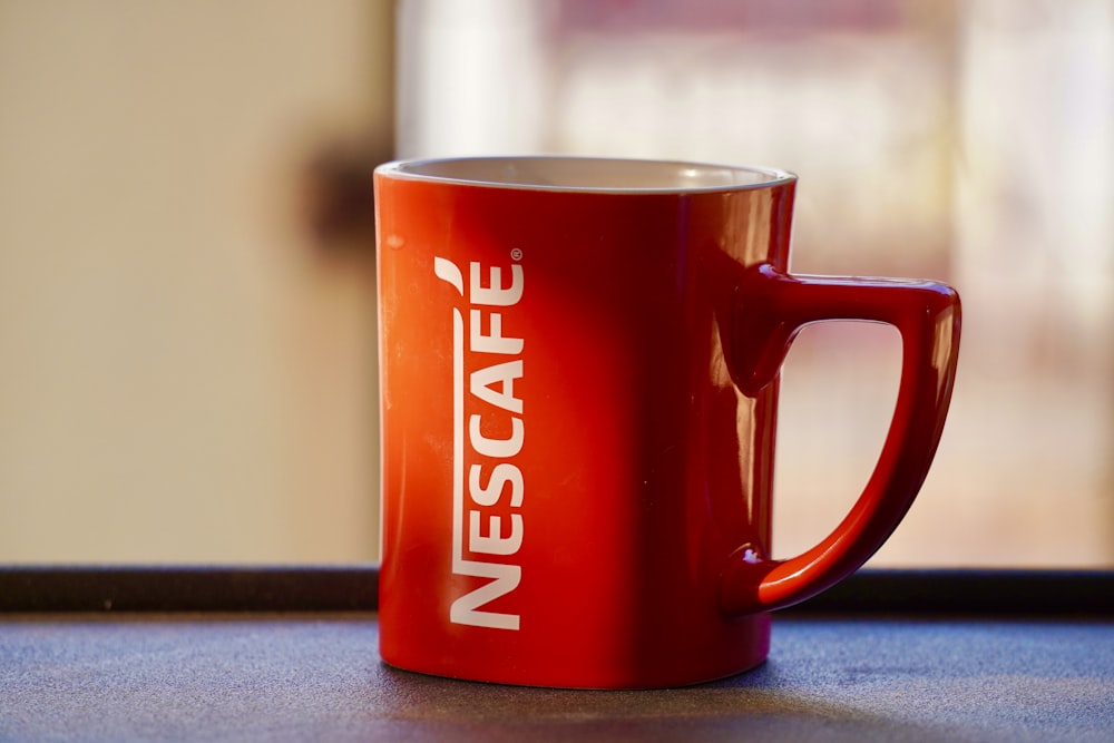 a red coffee mug sitting on top of a table