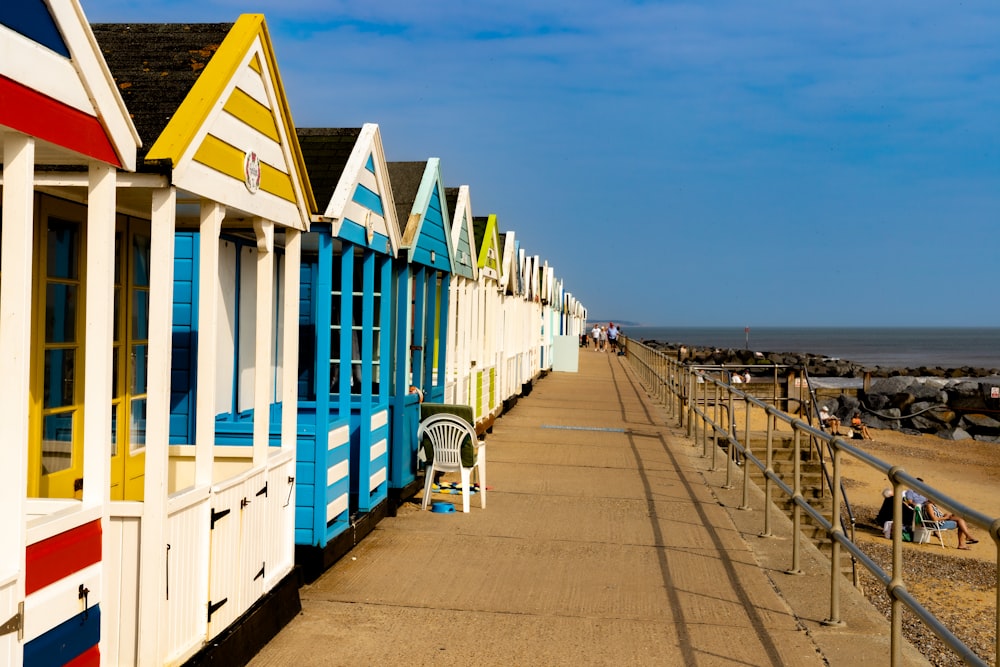 a row of colorful beach huts next to the ocean