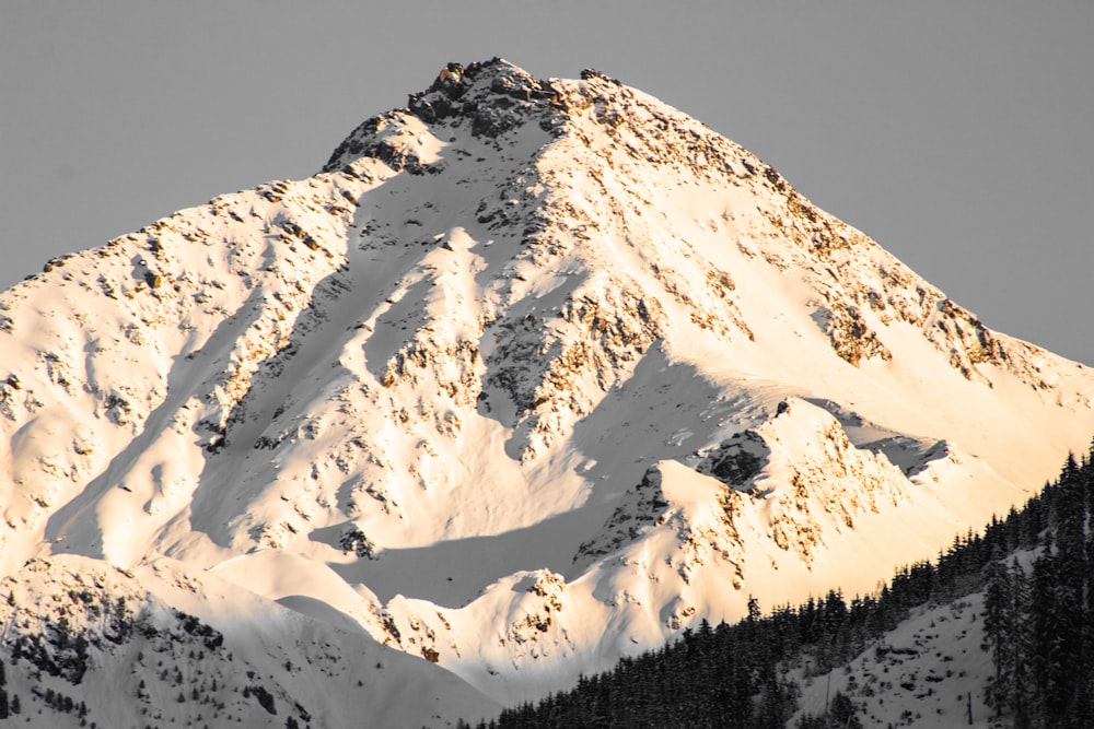 a large snow covered mountain with a sky background