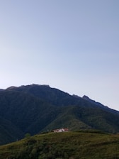 A serene view of a cozy vacation home surrounded by lush greenery and mountains.