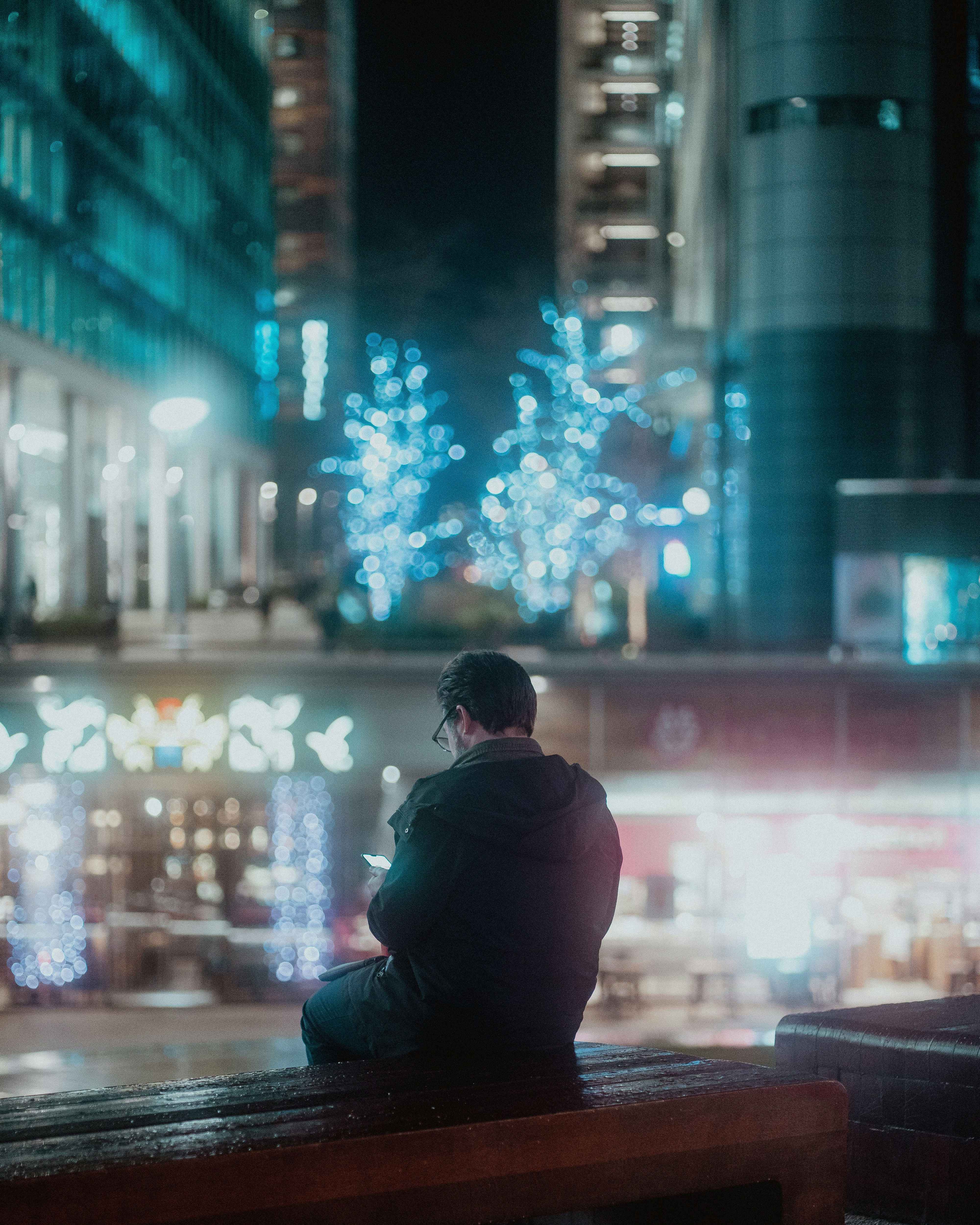a man sitting on a bench looking at fireworks