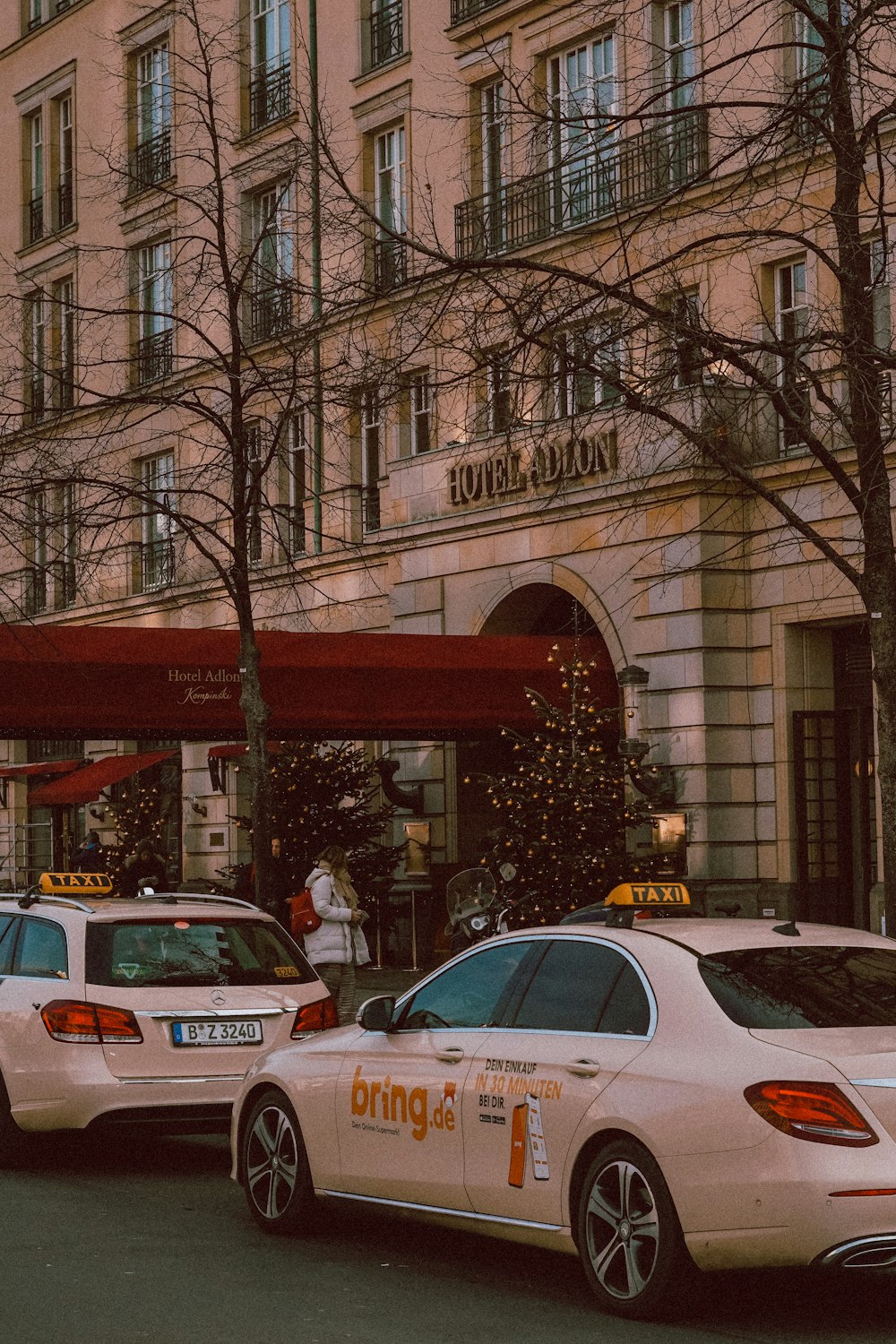 a couple of cars parked in front of a tall building