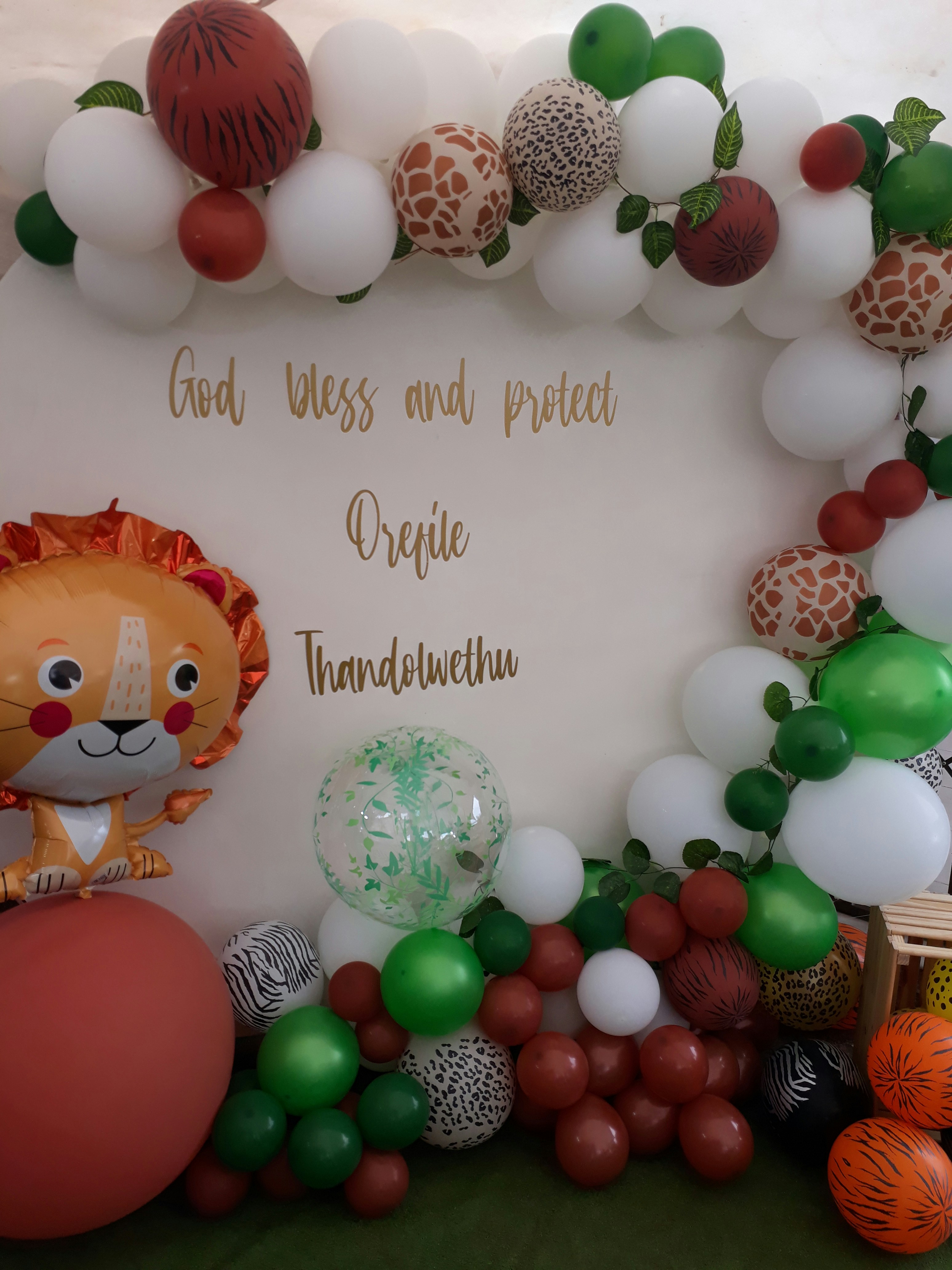 Safari baby shower with neutral animal decorations and jungle greenery