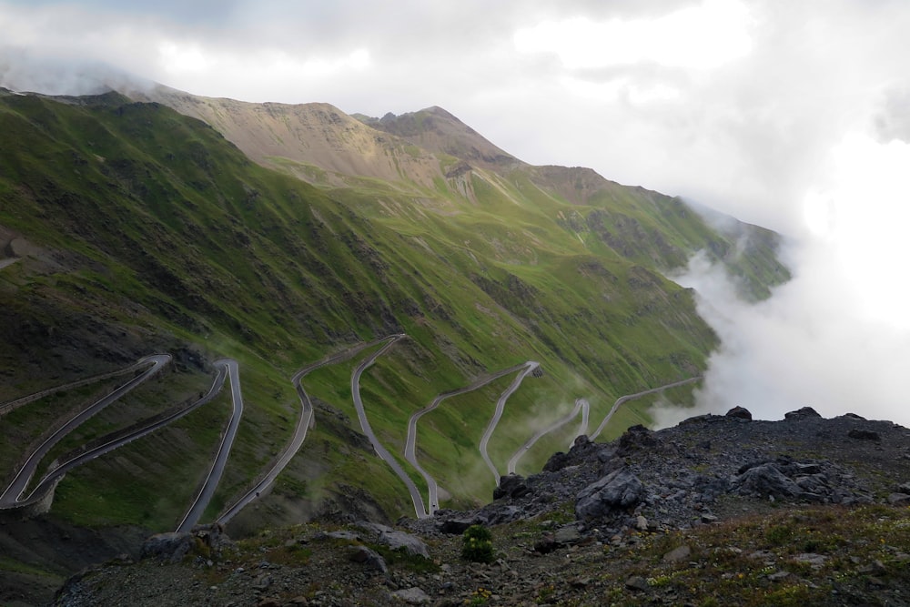 a winding mountain road in the middle of a valley