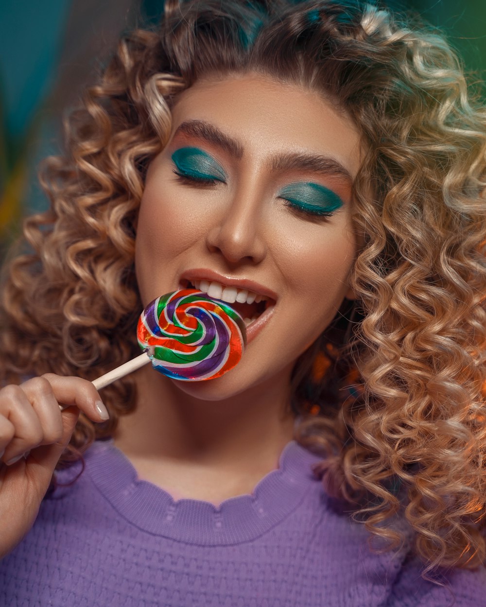 a woman holding a lollipop in her mouth